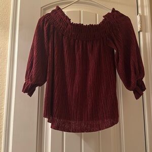 An over-the-shoulder maroon shirt